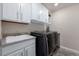 Laundry room with white cabinets, sink, and appliances for convenient laundry day at 8075 S Vandriver Way, Aurora, CO 80016