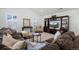 Comfortable living room features plush seating, modern entertainment center, and natural light from large windows at 8075 S Vandriver Way, Aurora, CO 80016