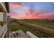 Outdoor patio with a fireplace and seating area, overlooking the golf course at sunset at 8075 S Vandriver Way, Aurora, CO 80016
