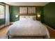 Bedroom with green walls features a plush bed, soft rug, and bright natural light at 1090 N Lafayette St # 305, Denver, CO 80218