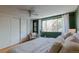 Green bedroom with white closet, large windows, and a comfy chair at 1090 N Lafayette St # 305, Denver, CO 80218