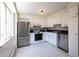 Functional kitchen with white cabinets, black countertops, and stainless steel appliances at 1090 N Lafayette St # 305, Denver, CO 80218