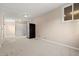 Large basement area with carpet, neutral walls, and a refrigerator providing versatile space for various uses at 7511 Locust St, Commerce City, CO 80022