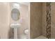 Well-lit bathroom featuring a pedestal sink, mosaic tiling, and a walk-in shower at 7511 Locust St, Commerce City, CO 80022