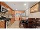 Well-lit kitchen with stainless appliances, granite counters, and adjacent dining area at 7511 Locust St, Commerce City, CO 80022