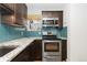 Modern kitchen with stainless steel appliances and blue tile backsplash at 3428 S Sherman St, Englewood, CO 80113