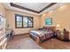 Cozy bedroom featuring a decorative wood tray ceiling and large windows offering natural light at 30 W Ranch Trl, Morrison, CO 80465
