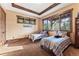 Bedroom with two beds, large windows, decorative wood tray ceiling, and an exterior view at 30 W Ranch Trl, Morrison, CO 80465