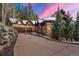 A beautiful exterior view of a luxury mountain home featuring an attached garage, paved driveway, and mature landscaping at 30 W Ranch Trl, Morrison, CO 80465