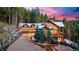 A grand exterior view of a luxury mountain home featuring an attached garage, beautiful landscaping, and stunning sunset at 30 W Ranch Trl, Morrison, CO 80465
