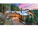 A grand exterior view of a luxury mountain home featuring an attached garage, stone accents, and a paved driveway at 30 W Ranch Trl, Morrison, CO 80465