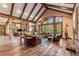 Expansive living room featuring timber beams, rustic wood floors and large windows with views of the outdoors at 30 W Ranch Trl, Morrison, CO 80465
