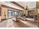 The light filled living room features stone fireplace, chandelier and wood beam ceiling at 30 W Ranch Trl, Morrison, CO 80465