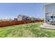 A spacious backyard featuring a well-maintained lawn, a patio dining set, and views of neighboring homes at 542 W 173Rd Ave, Broomfield, CO 80023