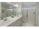 Bright bathroom featuring double sinks, modern fixtures, and a glass-enclosed shower at 542 W 173Rd Ave, Broomfield, CO 80023