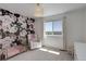 Bright Bedroom featuring a floral accent wall, gold crib, and cozy armchair at 542 W 173Rd Ave, Broomfield, CO 80023