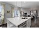 Modern kitchen island with a view to a dining area, a living room, and large windows at 542 W 173Rd Ave, Broomfield, CO 80023