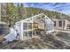 Outdoor greenhouse with an antique car inside, surrounded by greenery and a rustic setting at 2971 Fall River Rd, Idaho Springs, CO 80452