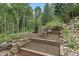 Horseshoe pit surrounded by trees; includes outdoor seating, barrel smoker and firewood storage at 2971 Fall River Rd, Idaho Springs, CO 80452