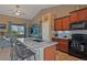 Open kitchen with an island, granite countertops, and ceiling fan at 5351 Royal Pine St, Brighton, CO 80601