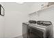 Functional laundry room features modern front load washer and dryer, with shelf storage above at 850 Mosquito Ct, Elizabeth, CO 80107