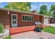 Charming brick home featuring a welcoming red deck, beautiful landscaping, and inviting curb appeal at 1040 Zang St, Golden, CO 80401