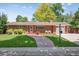 Charming red brick home with a manicured lawn and a stone walkway to the front door at 1040 Zang St, Golden, CO 80401