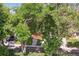 Charming home with a landscaped front yard, walkway, and a vibrant red porch viewed through the trees at 1040 Zang St, Golden, CO 80401
