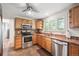 Well-lit kitchen with stainless steel appliances, warm wood cabinets, and tile flooring at 1040 Zang St, Golden, CO 80401