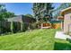 Spacious backyard with lush green lawn, mature trees, privacy fence, and a relaxing hammock for leisure and enjoyment at 583 S York St, Denver, CO 80209