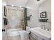 Neutral bathroom with a shower-tub, tan tile surround, a large sink, and new fixtures at 583 S York St, Denver, CO 80209