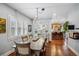 Elegant dining room with hardwood floors, a modern light fixture, and large windows with plantation shutters at 583 S York St, Denver, CO 80209