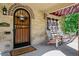 Cozy front porch with a wooden door, brick accents, and seating for relaxing outdoors at 583 S York St, Denver, CO 80209
