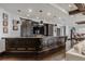 Basement bar with custom cabinets, stone countertop, pendant lighting, and entertainment area at 1820 Mallard Dr, Broomfield, CO 80020