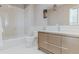 Bright bathroom with a white tile shower/tub and a stylish wood vanity with modern fixtures at 1820 Mallard Dr, Broomfield, CO 80020