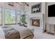 Bright main bedroom boasting a fireplace, large windows with nature views, and modern decor at 1820 Mallard Dr, Broomfield, CO 80020
