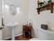 Powder room featuring a pedestal sink, decorative mirror, and modern fixtures at 7638 S Hudson Way, Centennial, CO 80122