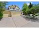 Well-maintained yellow two-story home with a spacious driveway and beautifully landscaped front yard at 7638 S Hudson Way, Centennial, CO 80122
