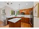 Well-lit kitchen featuring wooden cabinets, white countertops, an island, and modern appliances at 7638 S Hudson Way, Centennial, CO 80122