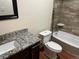 Bathroom featuring granite countertop, tiled walls, and a modern toilet at 22822 E Union Cir, Aurora, CO 80015