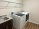 Laundry room with stainless steel sink and appliances, plus an overhead rack for storage at 22822 E Union Cir, Aurora, CO 80015