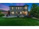 Backyard with a well-maintained lawn, a stone patio, a built-in fire pit, and lush landscaping at 2647 Gray Wolf Loop, Broomfield, CO 80023