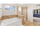 Bathroom featuring a soaking tub, a tiled walk-in shower, and a large window at 2647 Gray Wolf Loop, Broomfield, CO 80023