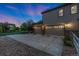 View of a three-car garage with well-lit windows and a concrete driveway, surrounded by lush landscaping at 2647 Gray Wolf Loop, Broomfield, CO 80023
