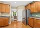 Well-designed kitchen with stainless steel refrigerator, wood cabinets, and access to dining room at 2647 Gray Wolf Loop, Broomfield, CO 80023