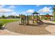 Well-maintained playground with slides, climbing area, and picnic shelter, surrounded by wood chips and concrete walkways at 2647 Gray Wolf Loop, Broomfield, CO 80023
