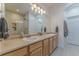 Bright bathroom featuring double sinks, wood cabinets, and glass enclosed shower at 11277 Osage Cir # E, Westminster, CO 80234