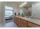 Bright bathroom with double sinks reflected in the large mirror; the main bedroom is visible at 11277 Osage Cir # E, Westminster, CO 80234