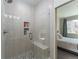 Modern glass enclosed shower with bench seat, shower caddy, and unique tiled floor at 11277 Osage Cir # E, Westminster, CO 80234