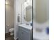Charming powder room featuring a gray vanity, oval mirror, and neutral walls at 11277 Osage Cir # E, Westminster, CO 80234